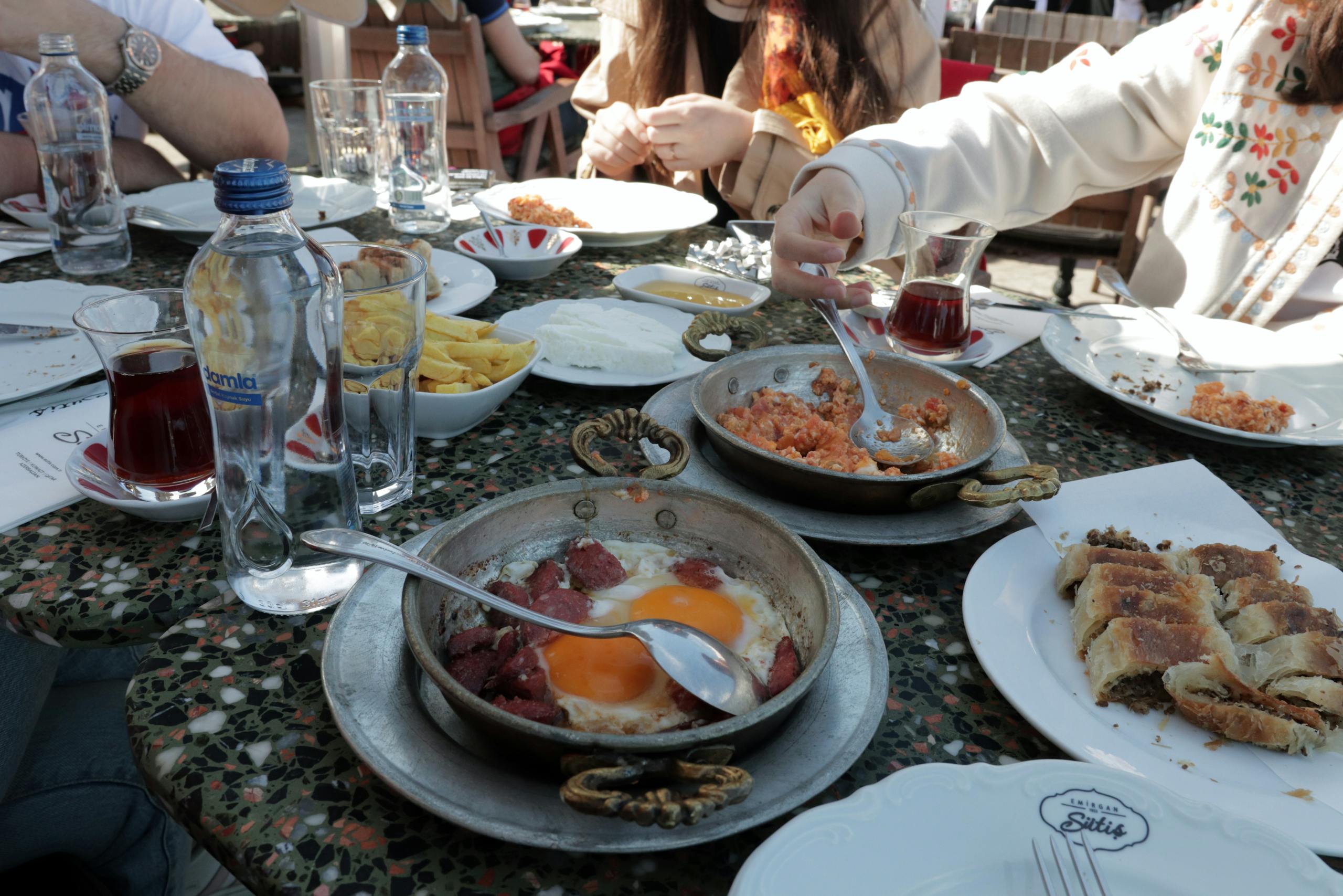 A group of people sitting at a table with plates of food