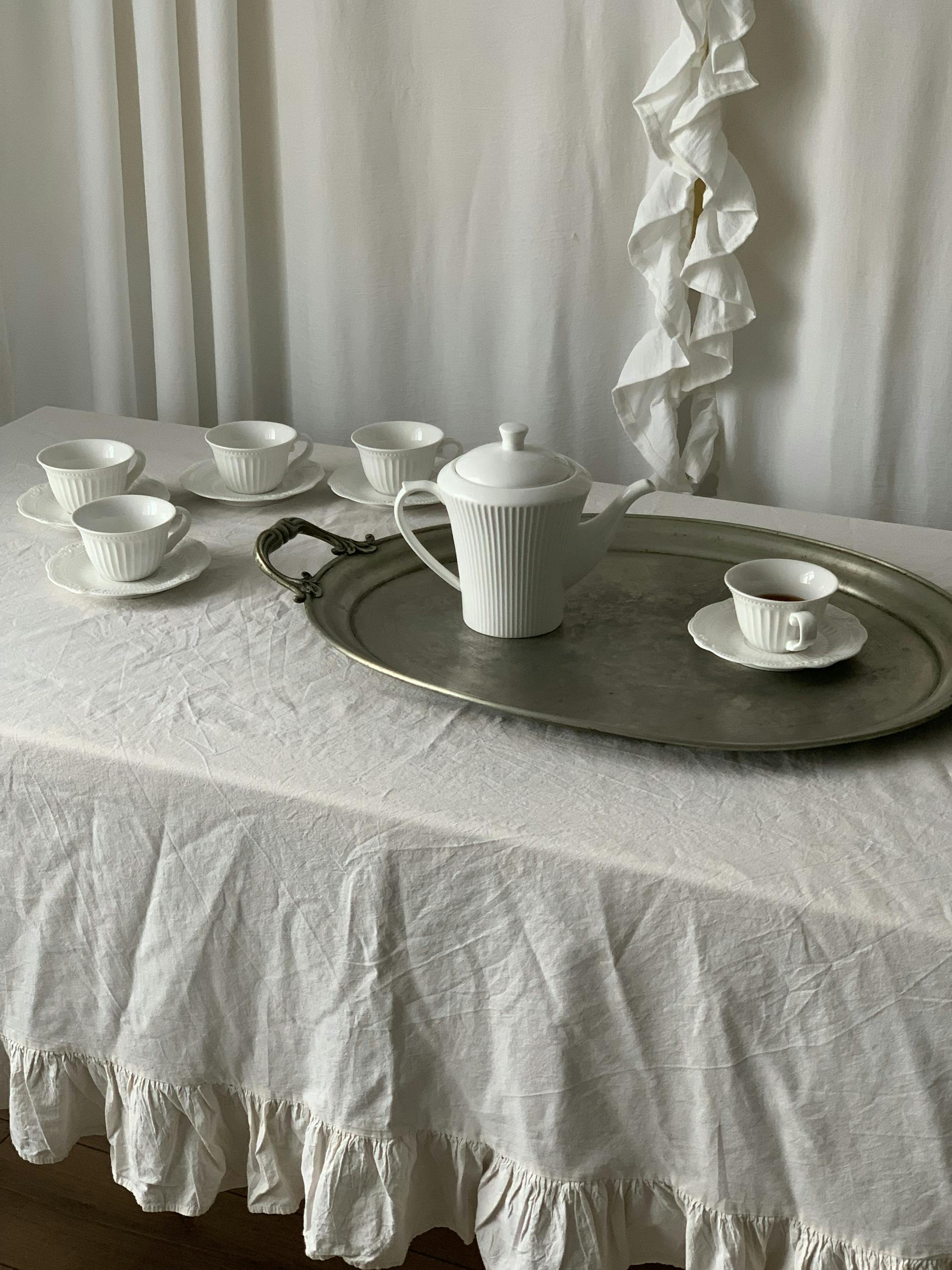 A table with a white tablecloth and tea cups