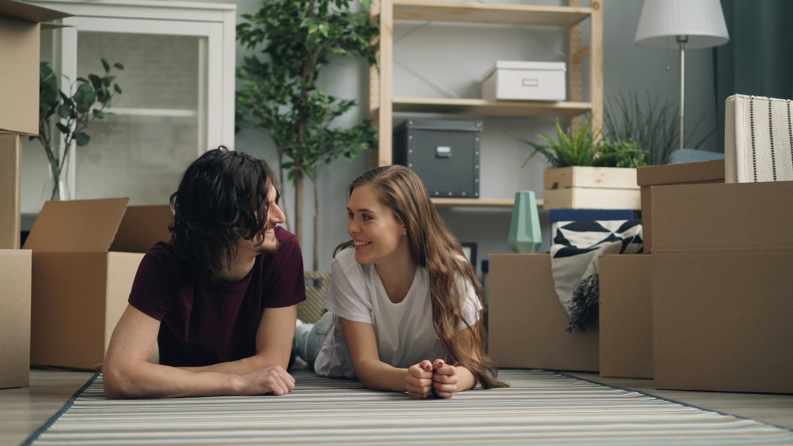 A young couple sitting on the floor in front of boxes